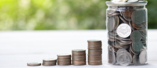 Un pot en verre rempli de pièces de monnaies